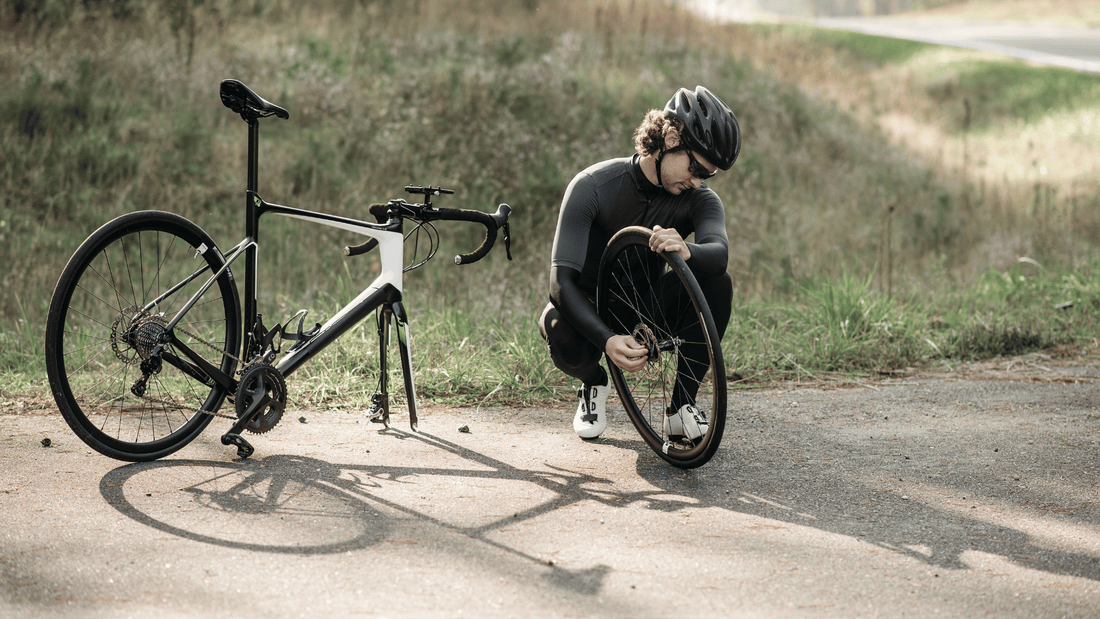 Mann repariert Fahrrad draußen